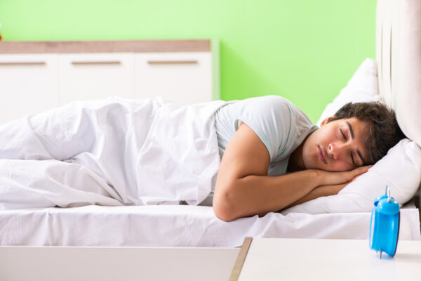Young man having trouble waking up in early morning
