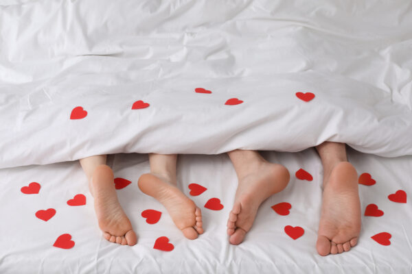 Couple allongé dans son lit avec des cœurs rouges, gros plan