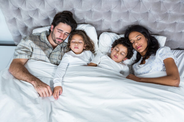 Famille dormant ensemble dans un lit