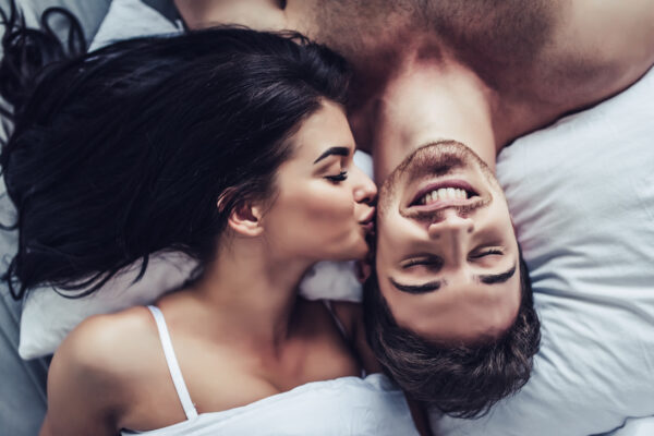 Gros plan d'un couple heureux, allongés au lit, profitant de leur compagnie.